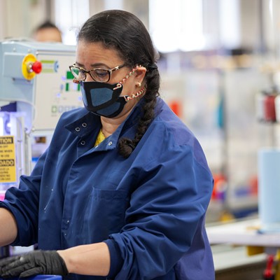 New Balance associate using and fabricating face masks at the company’s Lawrence, MA factory.